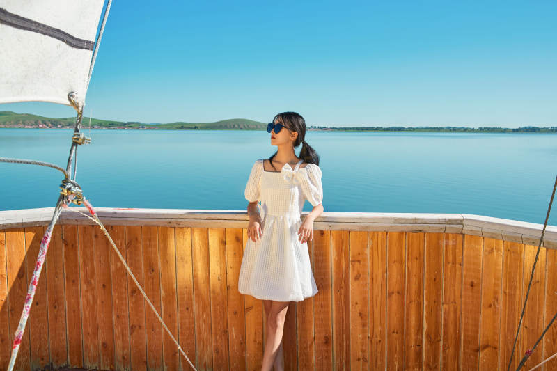 在湖畔木制帆船上的亚洲美女图片