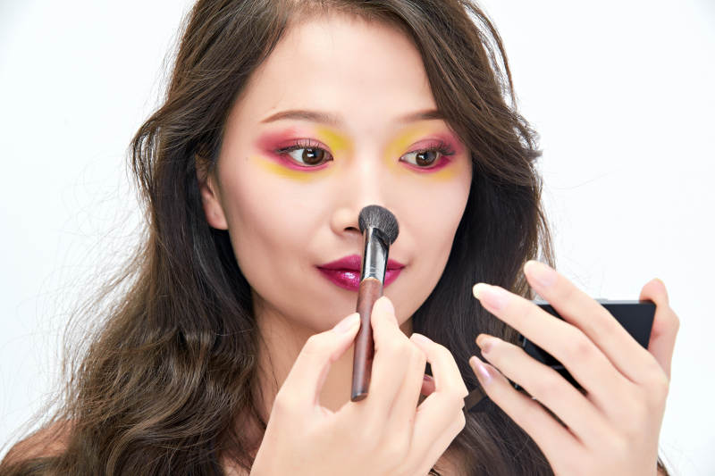 白色背景下棚拍化妆中的美女图片