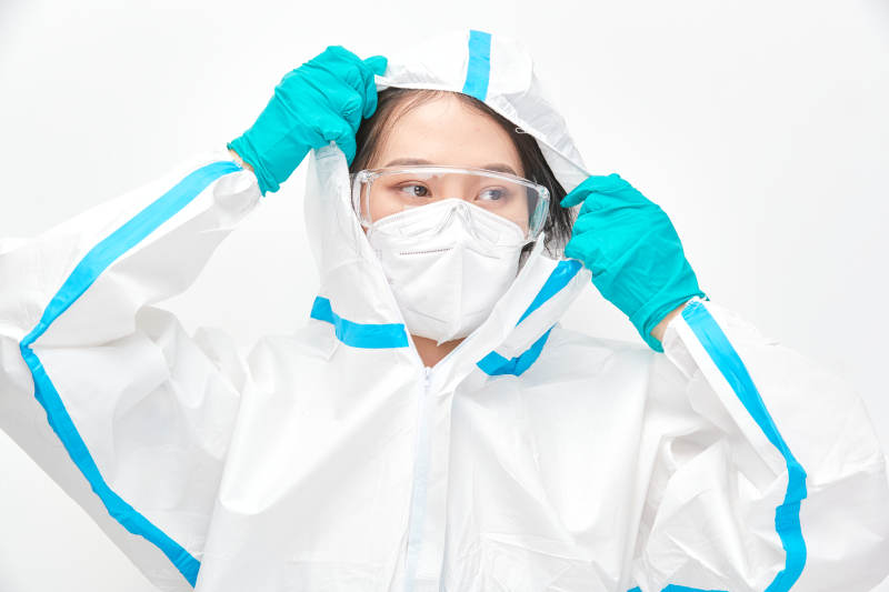 穿白色防护服佩戴护目镜口罩的女性医疗人员图片