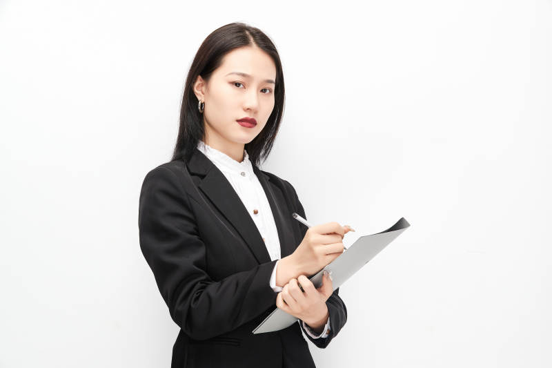 身穿西服拿着文件夹的美丽商务女士图片