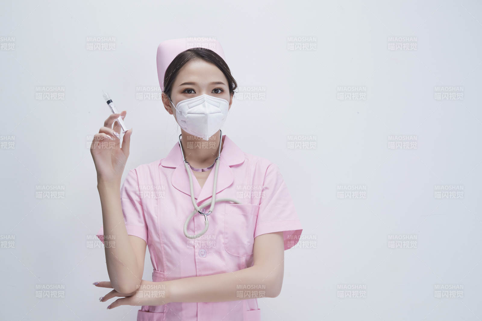 穿护士服戴听诊器口罩手执针筒的年轻女护士图片