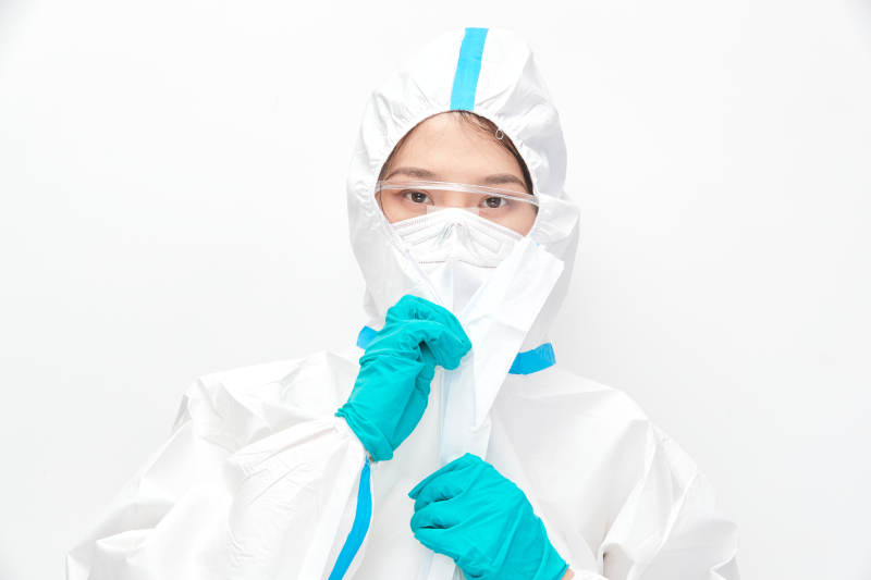 穿白色防护服佩戴护目镜口罩的女性医疗人员图片