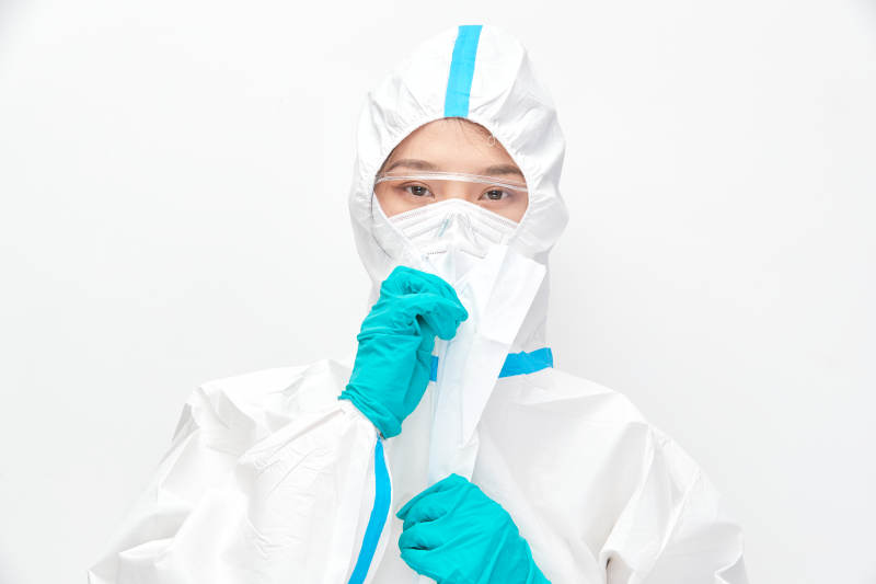 穿白色防护服佩戴护目镜口罩的女性医疗人员图片