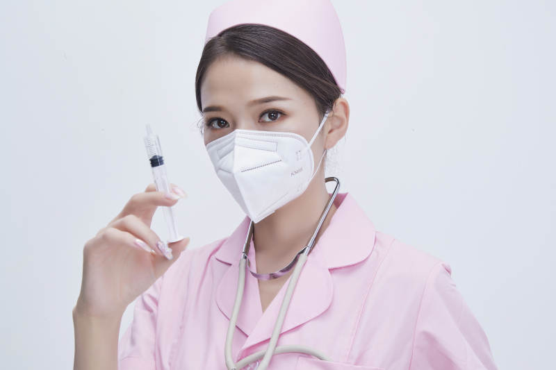 穿护士服戴听诊器口罩手执针筒的年轻女护士图片