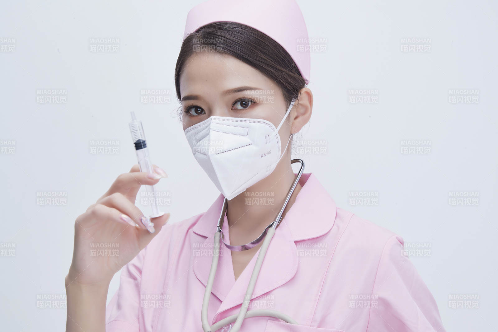 穿护士服戴听诊器口罩手执针筒的年轻女护士图片