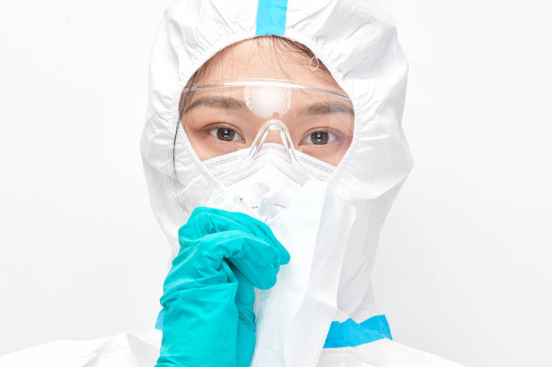 穿白色防护服佩戴护目镜口罩的女性医疗人员图片