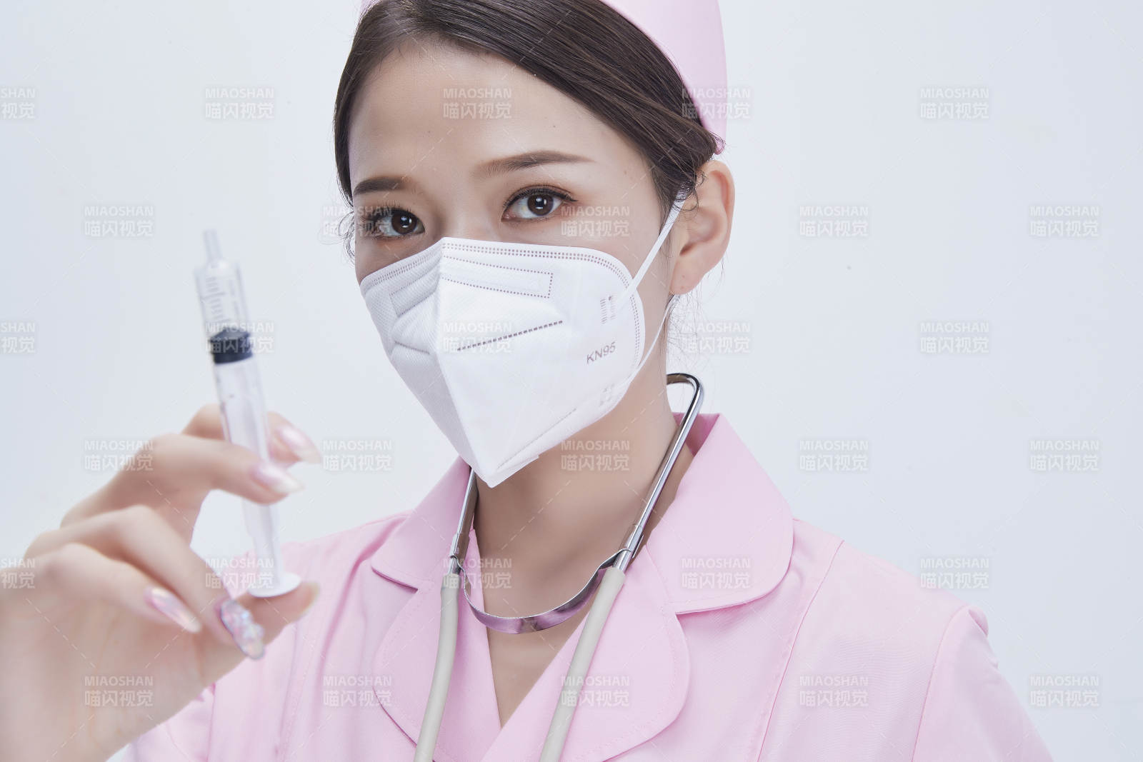 穿护士服戴听诊器口罩手执针筒的年轻女护士图片