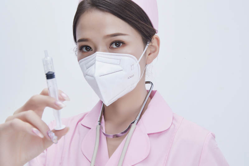穿护士服戴听诊器口罩手执针筒的年轻女护士图片