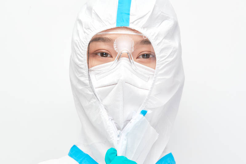 穿白色防护服佩戴护目镜口罩的女性医疗人员图片