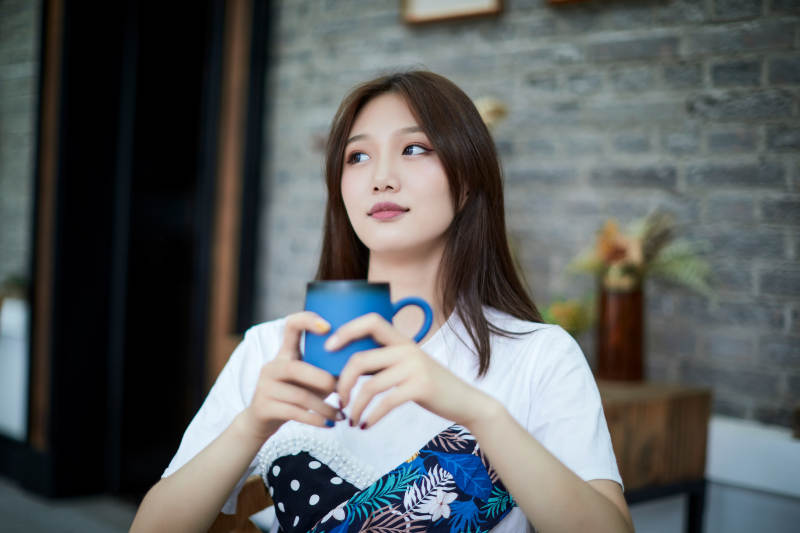 坐在咖啡图书馆吃东西的可爱少女图片