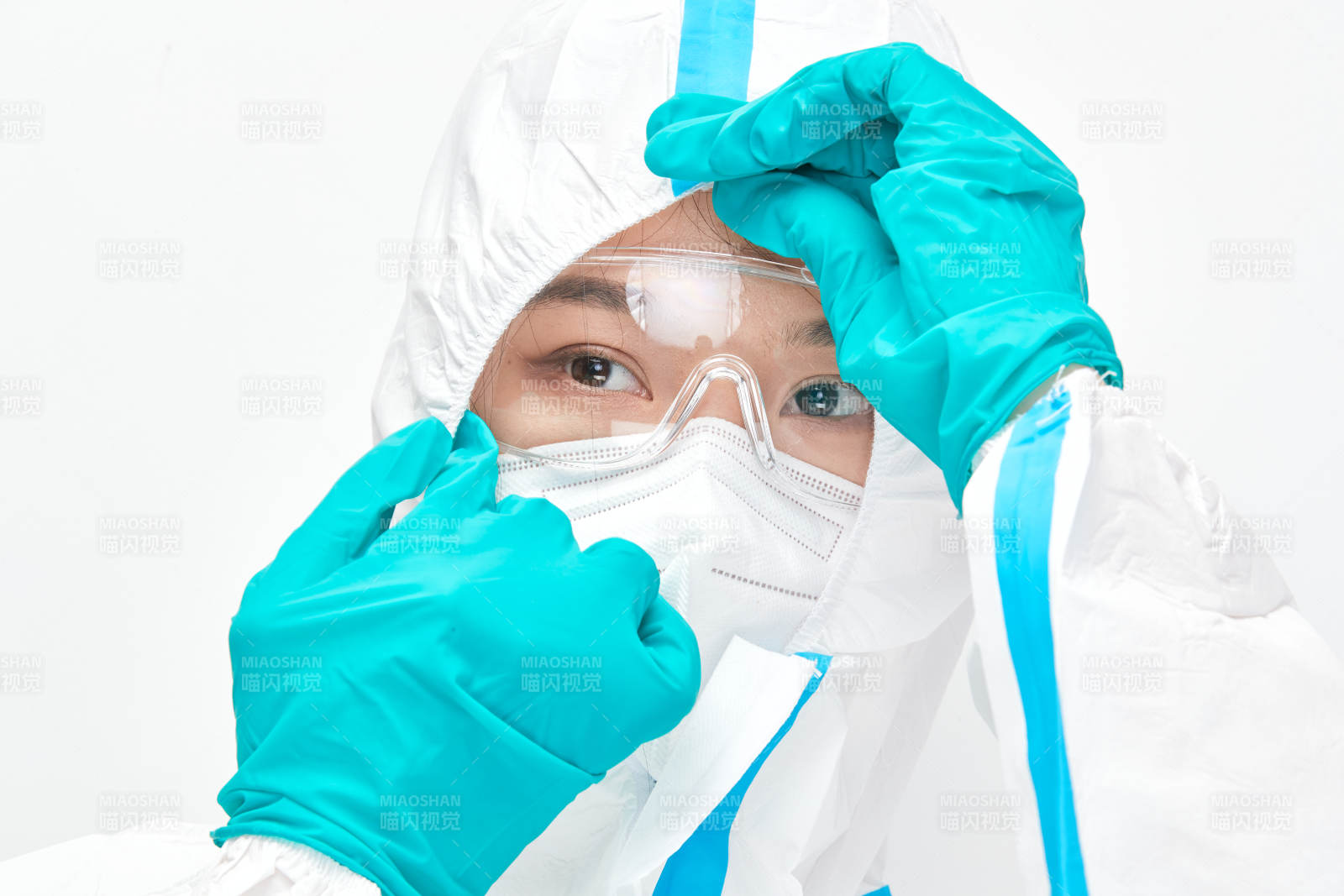 穿白色防护服佩戴护目镜口罩的女性医疗人员图片