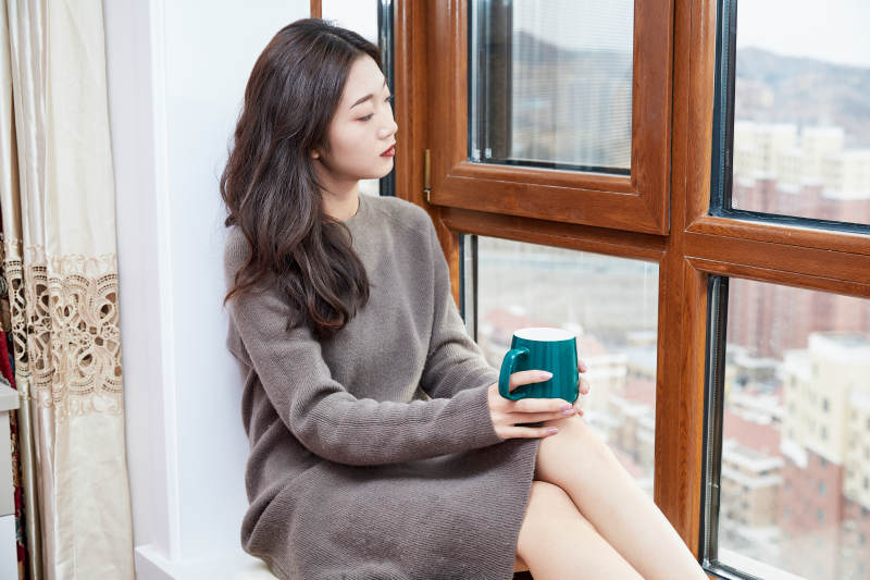 躺在舒适的飘窗上喝咖啡的少女图片