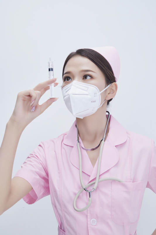 穿护士服戴听诊器口罩手执针筒的年轻女护士图片