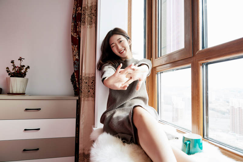 躺在舒适的飘窗上喝咖啡的少女图片