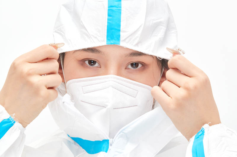 穿白色防护服佩戴护目镜口罩的女性医疗人员图片