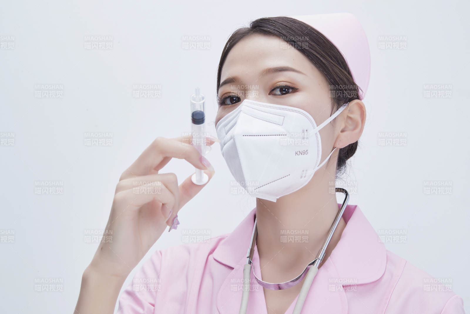 穿护士服戴听诊器口罩手执针筒的年轻女护士图片