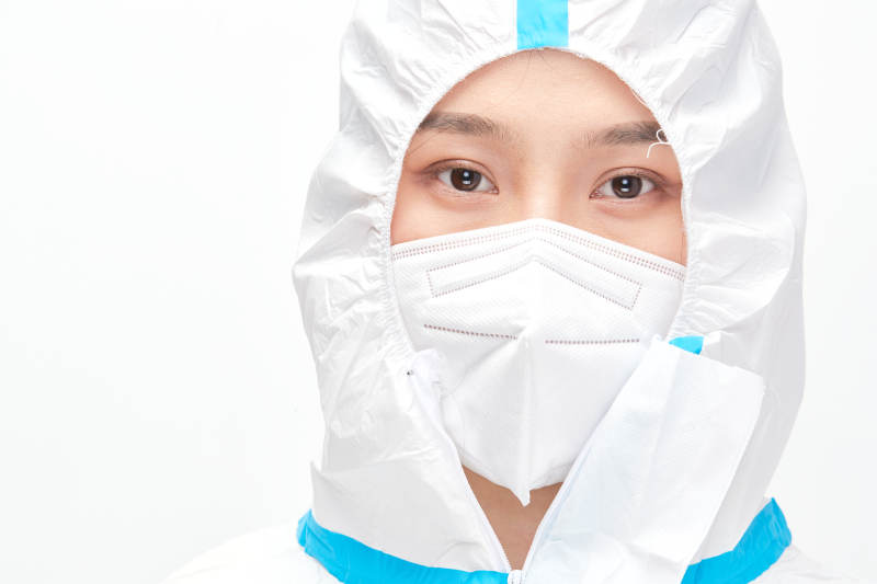 穿白色防护服佩戴护目镜口罩的女性医疗人员图片