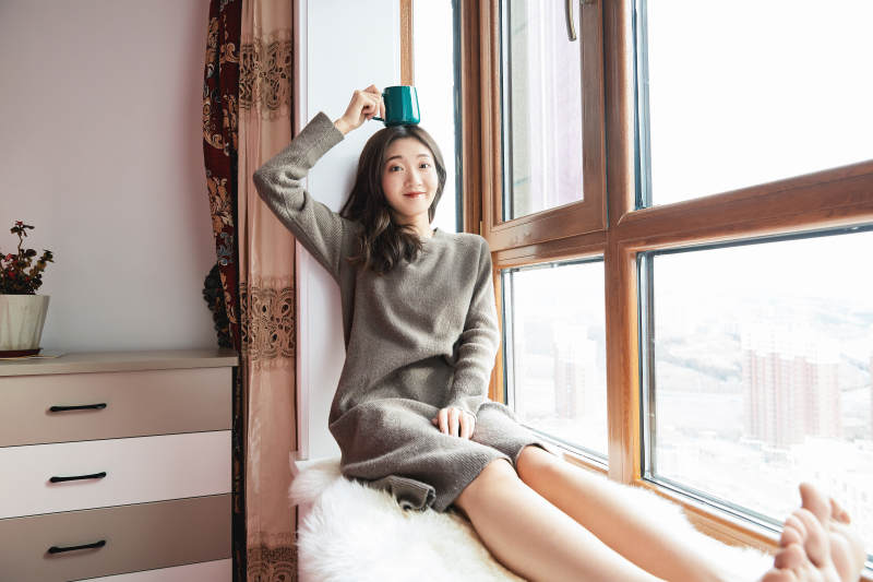 躺在舒适的飘窗上喝咖啡的少女图片