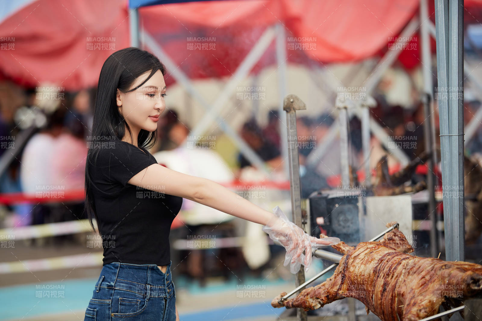 在户外烤全羊自助餐会品尝美食的美女图片