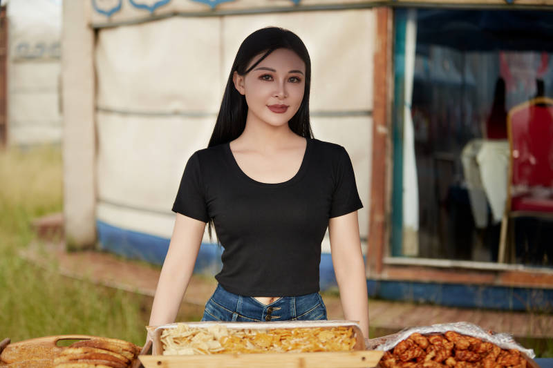 在户外烤全羊自助餐会品尝美食的美女图片