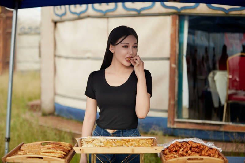 在户外烤全羊自助餐会品尝美食的美女图片