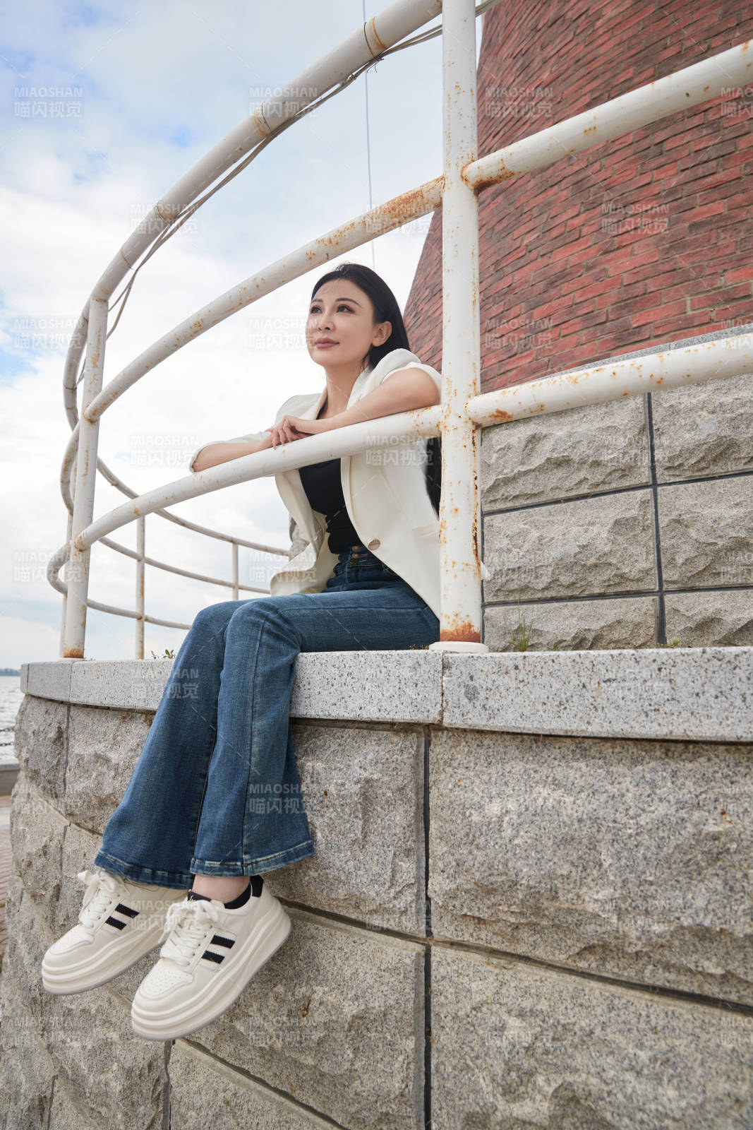 盛夏在景区湖边灯塔上拍照游玩的美女图片