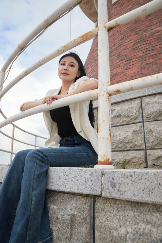 盛夏在景区湖边灯塔上拍照游玩的美女图片