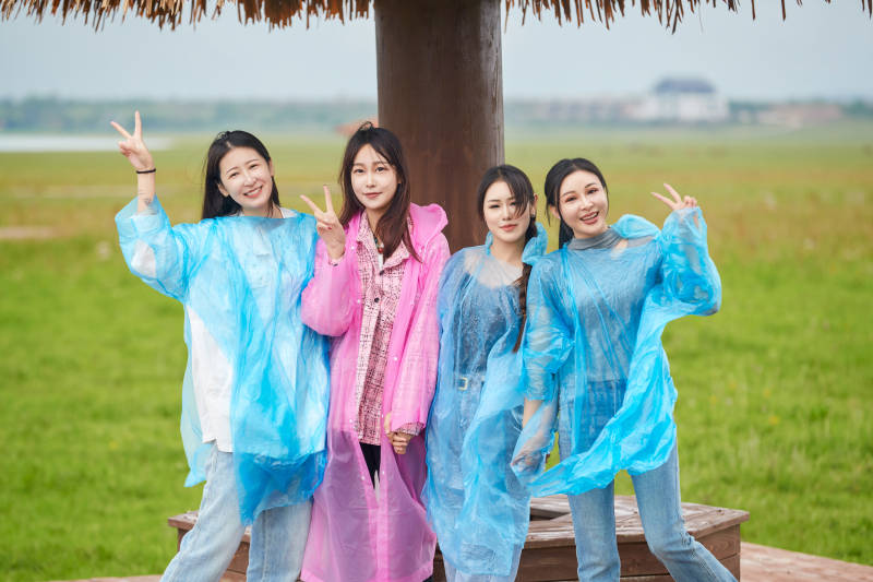 阴雨天在草原花海拍照的闺蜜四人图片