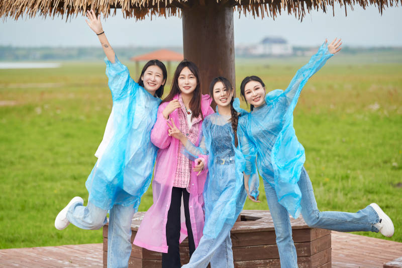 阴雨天在草原花海拍照的闺蜜四人图片