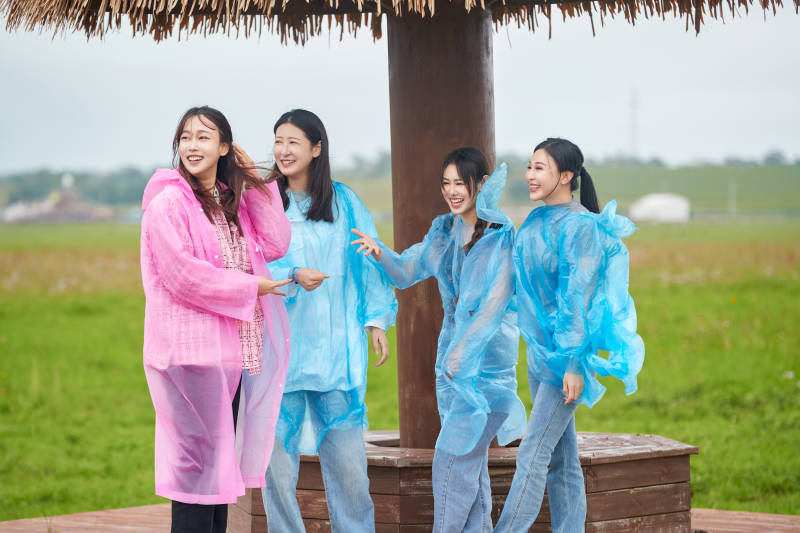 阴雨天在草原花海拍照的闺蜜四人图片