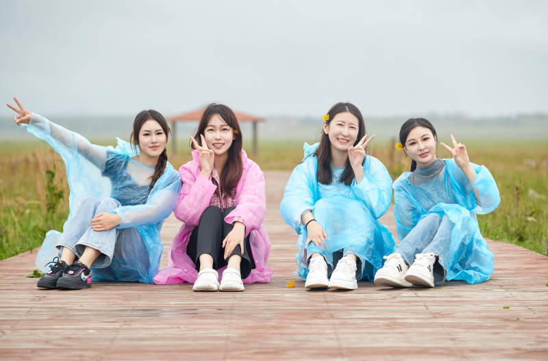 阴雨天在草原花海拍照的闺蜜四人图片