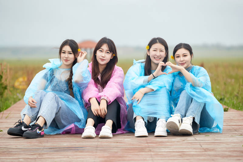 阴雨天在草原花海拍照的闺蜜四人图片