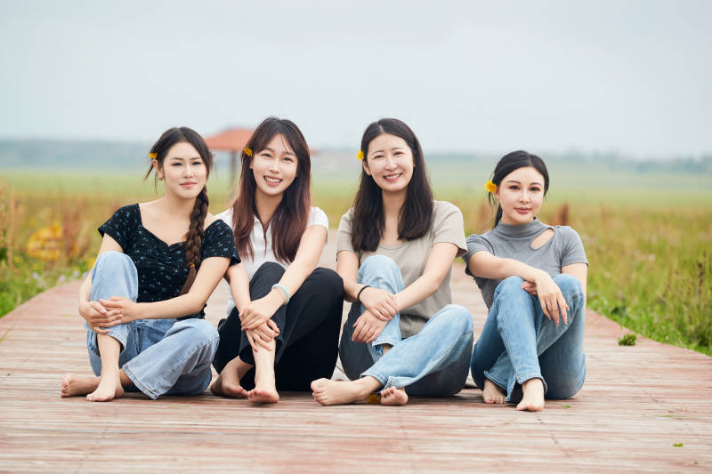 阴雨天在草原花海拍照的闺蜜四人图片