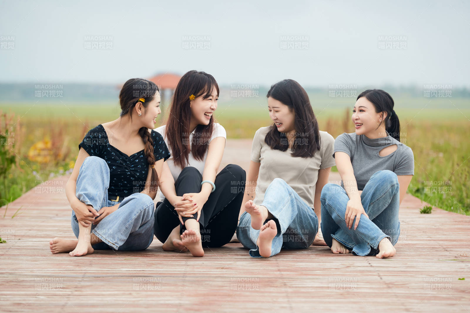 阴雨天在草原花海拍照的闺蜜四人图片