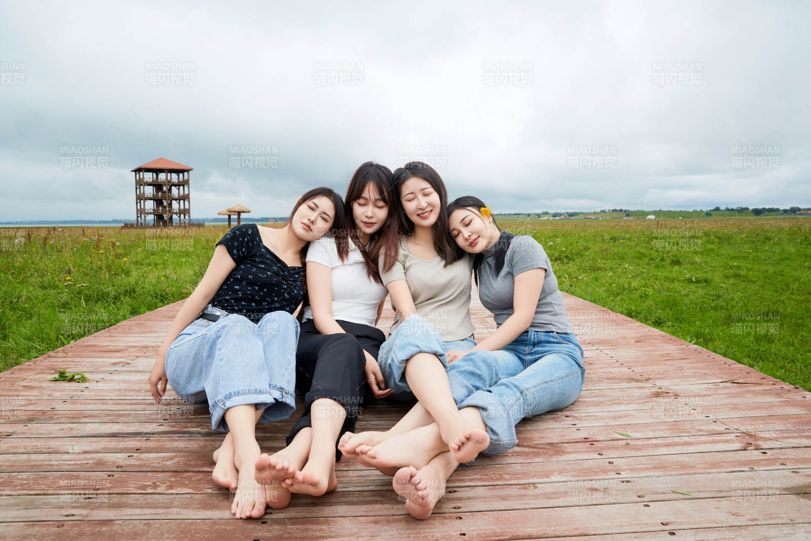 阴雨天在草原花海拍照的闺蜜四人图片