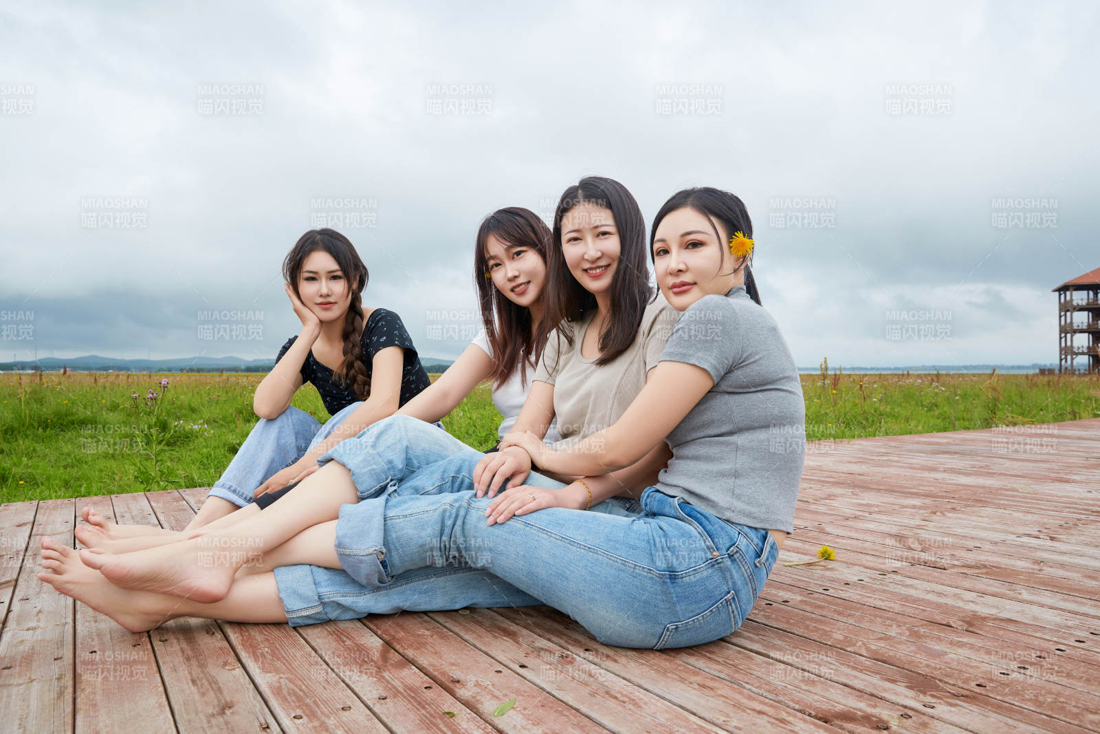 阴雨天在草原花海拍照的闺蜜四人图片