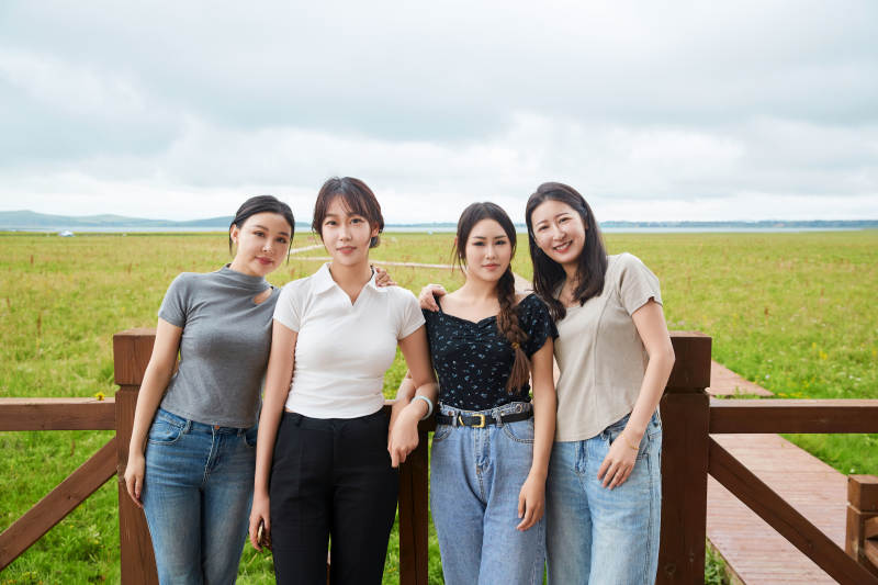 阴雨天在草原花海拍照的闺蜜四人图片