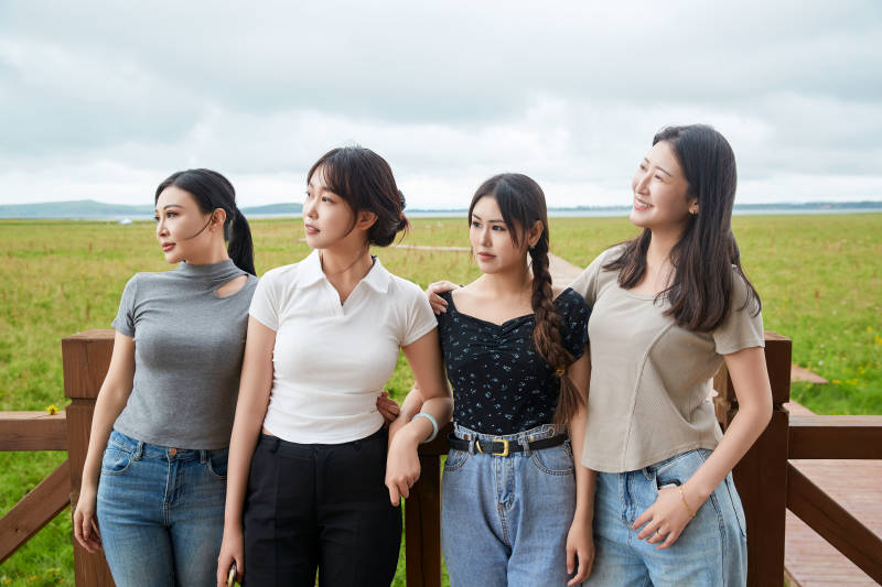 阴雨天在草原花海拍照的闺蜜四人图片