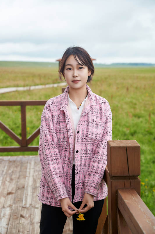 盛夏在草原花海拍照游玩的美女图片