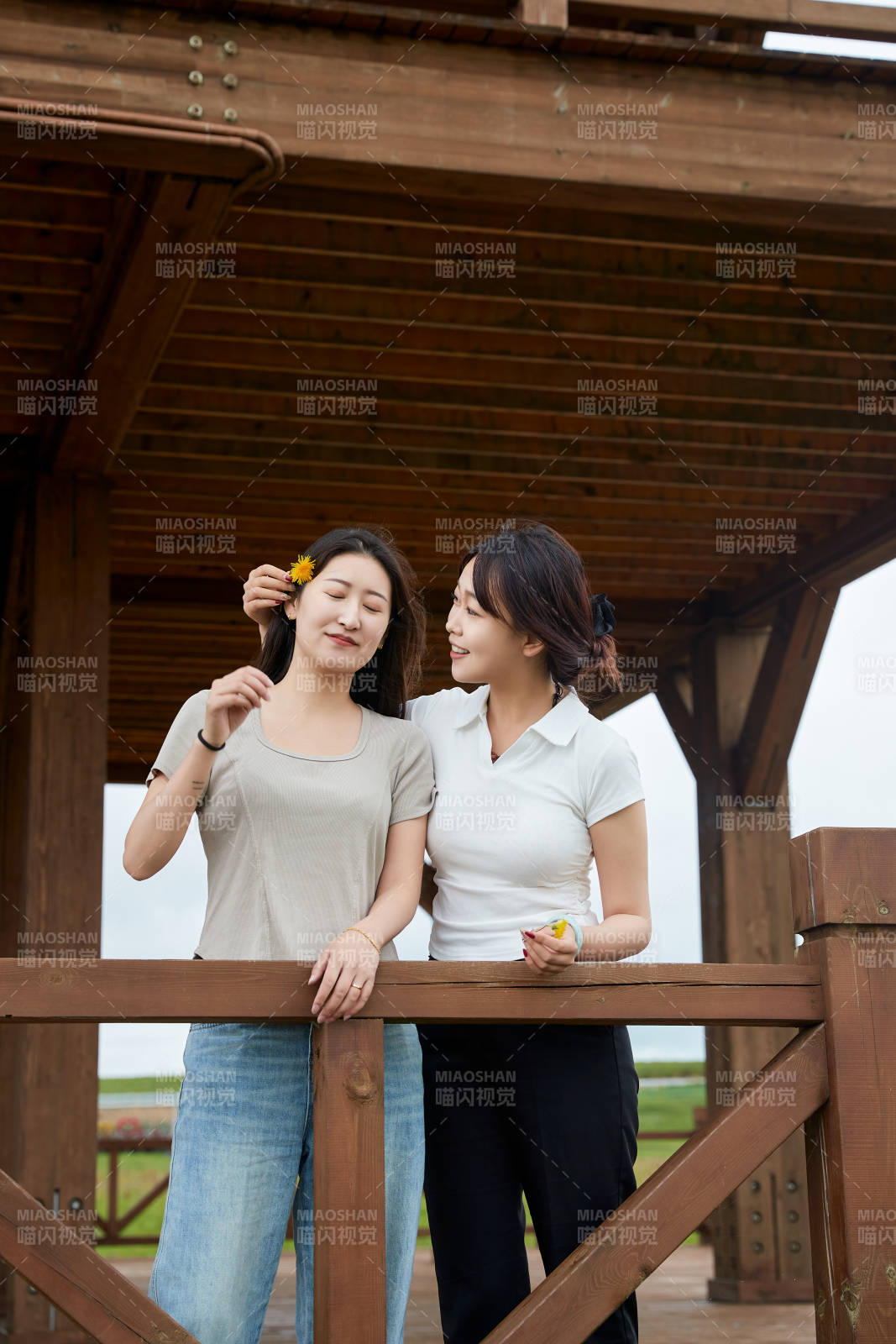 在草原花海观鸟台拍照游玩的美女闺蜜图片