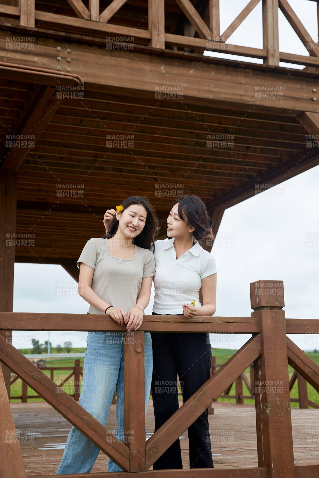 在草原花海观鸟台拍照游玩的美女闺蜜图片