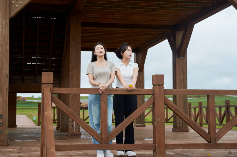 在草原花海观鸟台拍照游玩的美女闺蜜图片