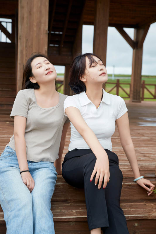 在草原花海观鸟台拍照游玩的美女闺蜜图片