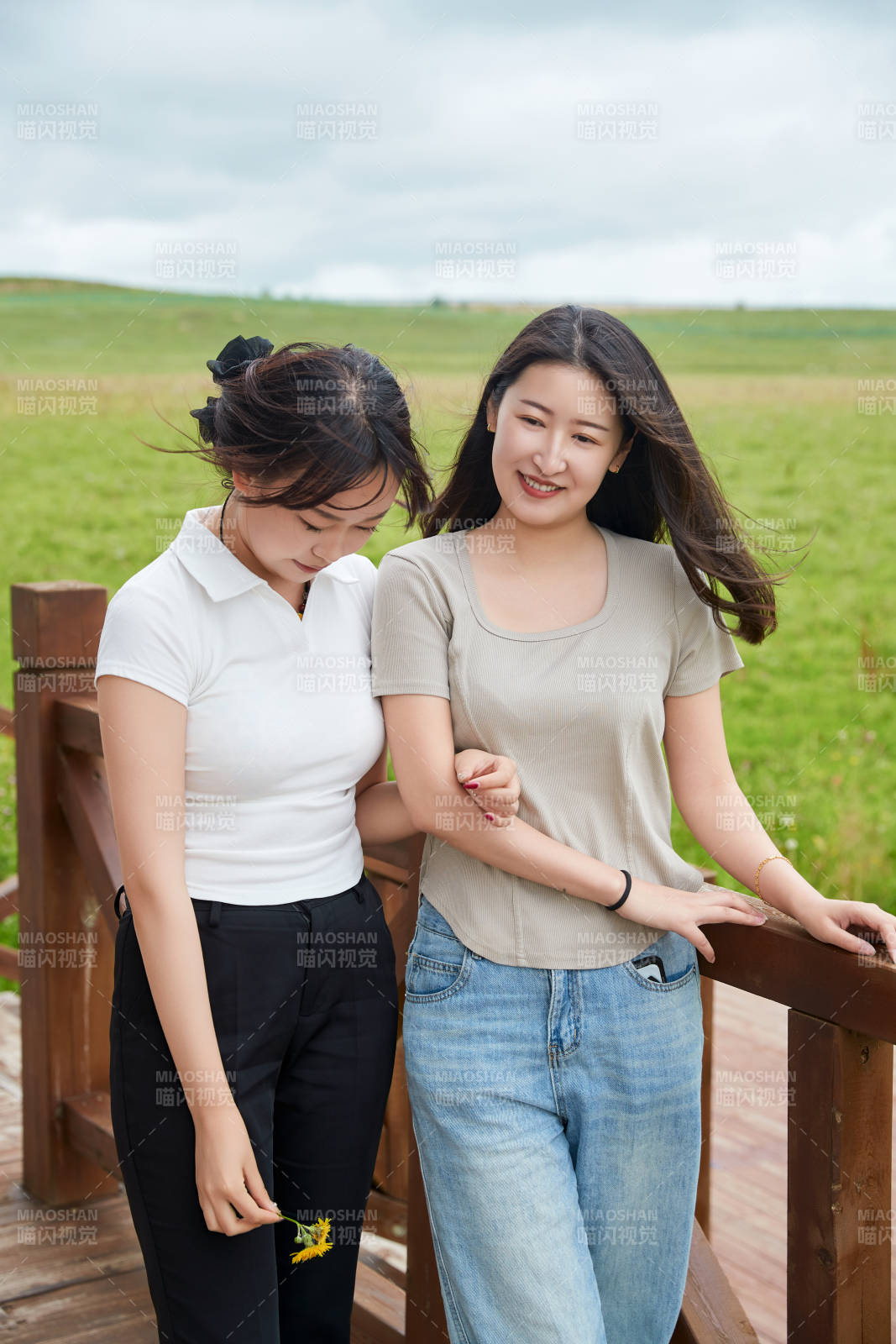 在草原花海观鸟台拍照游玩的美女闺蜜图片
