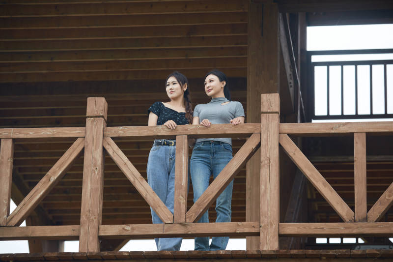 在草原花海观鸟台拍照游玩的美女闺蜜图片