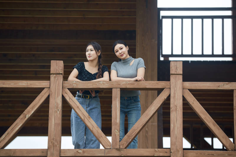 在草原花海观鸟台拍照游玩的美女闺蜜图片