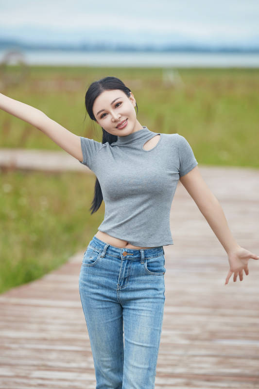 盛夏在草原花海拍照游玩的美女图片