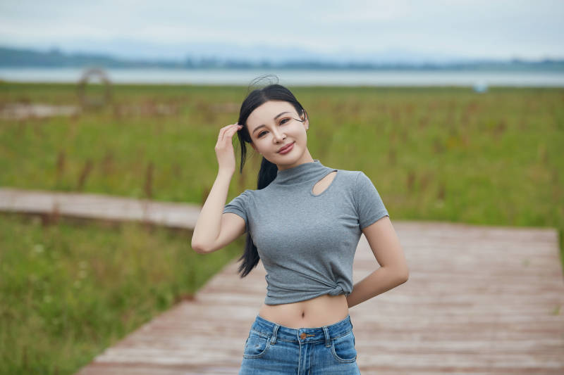 盛夏在草原花海拍照游玩的美女图片