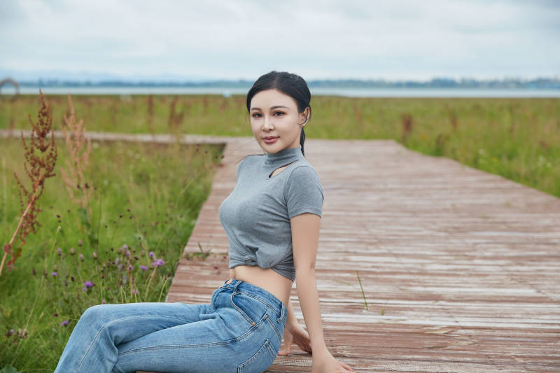 盛夏在草原花海拍照游玩的美女图片