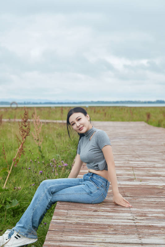 盛夏在草原花海拍照游玩的美女图片